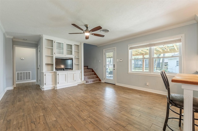 unfurnished living room with visible vents, baseboards, wood finished floors, and a ceiling fan