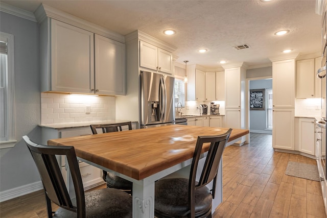 dining area featuring a wealth of natural light, visible vents, baseboards, and light wood-style floors