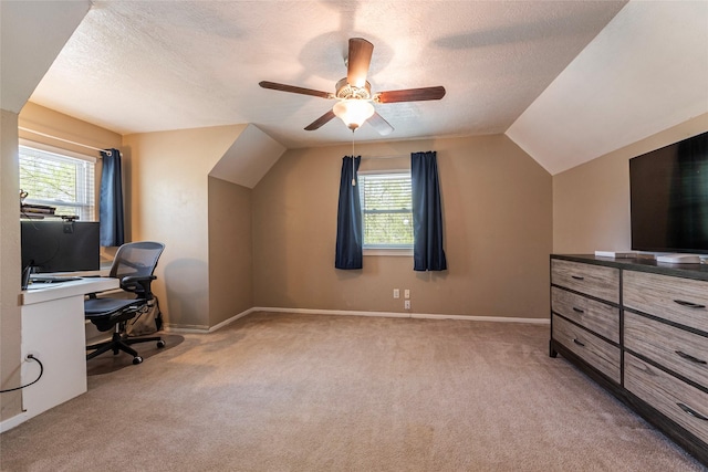 carpeted home office with plenty of natural light, a textured ceiling, ceiling fan, and vaulted ceiling