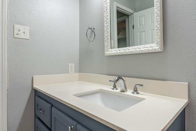 bathroom with vanity and a textured wall