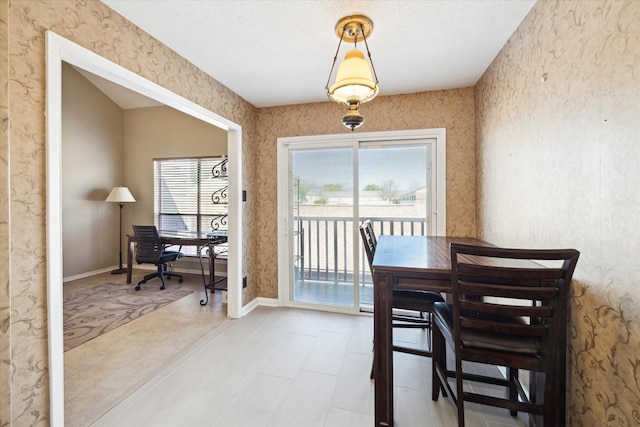 dining space featuring wallpapered walls, a healthy amount of sunlight, and baseboards