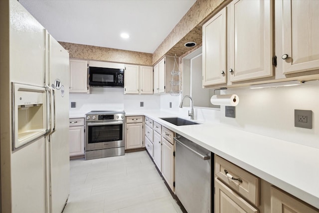 kitchen featuring recessed lighting, appliances with stainless steel finishes, light countertops, and a sink