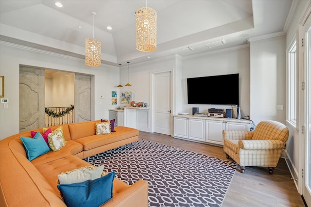 living room featuring a tray ceiling, wood finished floors, recessed lighting, crown molding, and vaulted ceiling