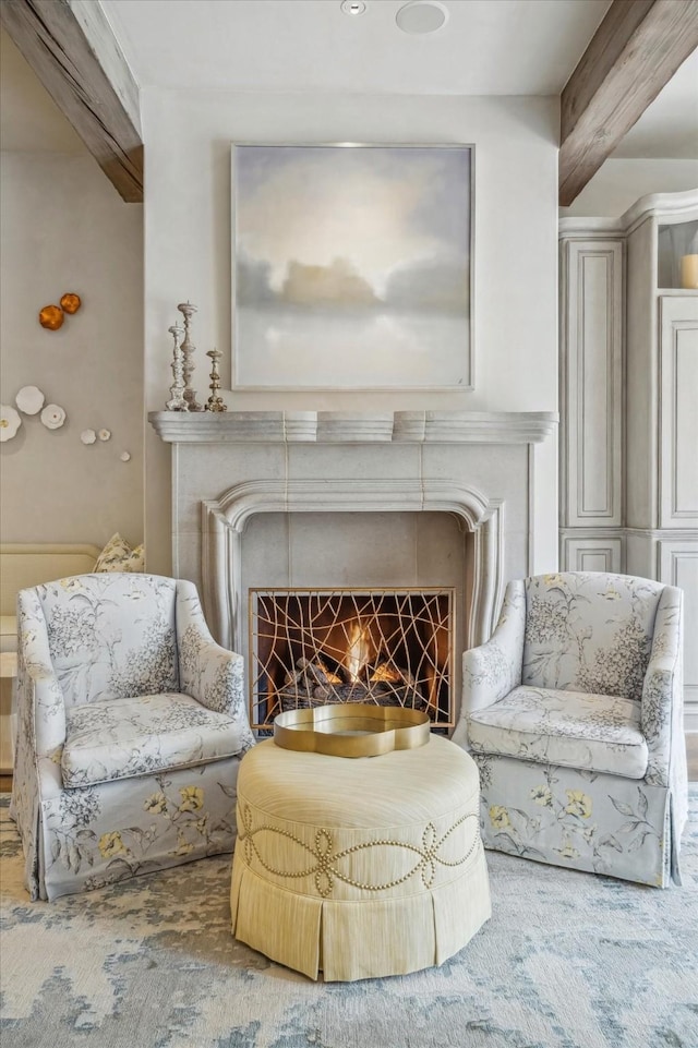 sitting room with beam ceiling and a fireplace