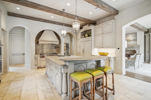 kitchen featuring tasteful backsplash, arched walkways, appliances with stainless steel finishes, and stone tile flooring