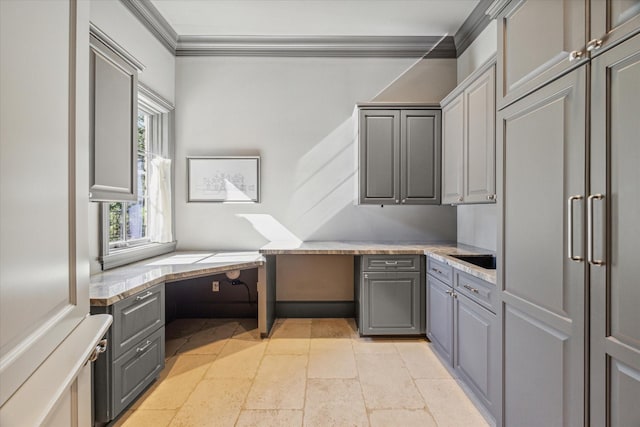 kitchen featuring built in desk, gray cabinetry, light countertops, and ornamental molding