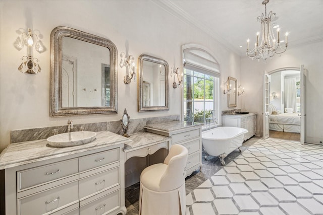 full bath with vanity, ensuite bath, an inviting chandelier, a freestanding bath, and ornamental molding