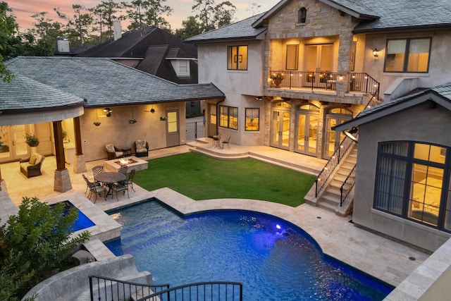 rear view of property with stairway, a balcony, stucco siding, french doors, and a patio area