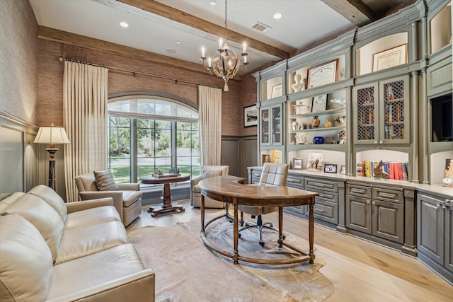 home office featuring visible vents, a wainscoted wall, light wood finished floors, an inviting chandelier, and beamed ceiling