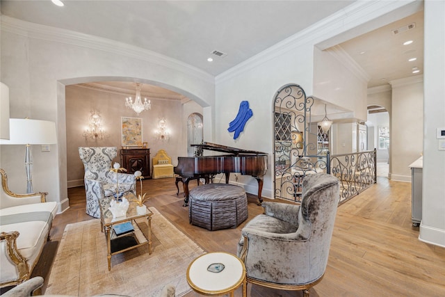 living room with arched walkways, visible vents, crown molding, and hardwood / wood-style floors