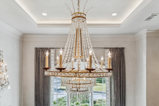 room details featuring visible vents, a raised ceiling, an inviting chandelier, and ornamental molding