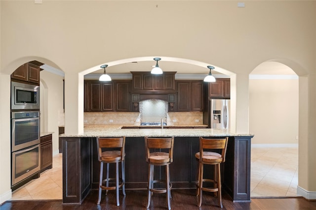 12530 Sharps Ln, Magnolia, TX 77354 - kitchen with appliances with stainless steel finishes, dark brown cabinets, tasteful backsplash, and a towering ceiling