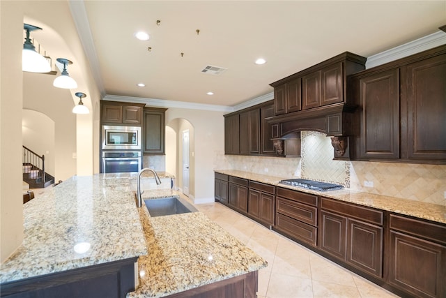 12530 Sharps Ln, Magnolia, TX 77354 - kitchen featuring appliances with stainless steel finishes, arched walkways, a sink, ornamental molding, and dark brown cabinets