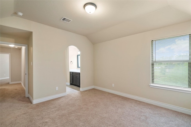 12530 Sharps Ln, Magnolia, TX 77354 - empty room featuring vaulted ceiling, light colored carpet, arched walkways, and baseboards