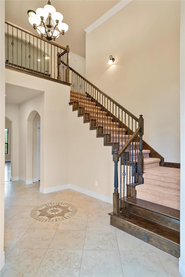 12530 Sharps Ln, Magnolia, TX 77354 - stairway with arched walkways, a chandelier, a high ceiling, baseboards, and crown molding