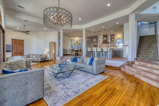 4206 Turks Pt, Galveston, TX 77554 - living room with visible vents, stairway, recessed lighting, ceiling fan with notable chandelier, and wood finished floors