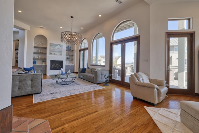 4206 Turks Pt, Galveston, TX 77554 - living area with a glass covered fireplace, a healthy amount of sunlight, built in shelves, and wood-type flooring