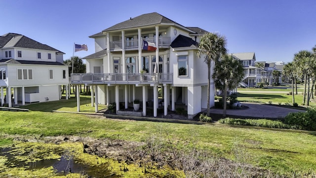 4206 Turks Pt, Galveston, TX 77554 - rear view of house featuring a balcony, a lawn, a residential view, and stucco siding