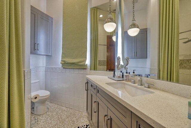 4206 Turks Pt, Galveston, TX 77554 - bathroom with tile patterned flooring, a wainscoted wall, toilet, vanity, and tile walls