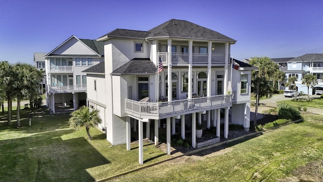 4206 Turks Pt, Galveston, TX 77554 - rear view of house with a balcony, a yard, a residential view, and stucco siding