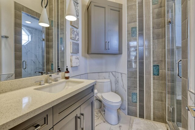 4206 Turks Pt, Galveston, TX 77554 - full bathroom with vanity, a wainscoted wall, a stall shower, tile walls, and toilet