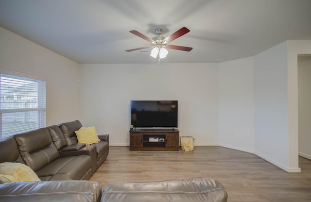 living room featuring baseboards, a ceiling fan, and wood finished floors