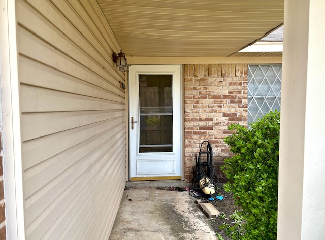 doorway to property featuring brick siding