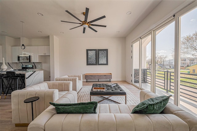 living area featuring a healthy amount of sunlight, recessed lighting, a ceiling fan, and light wood finished floors
