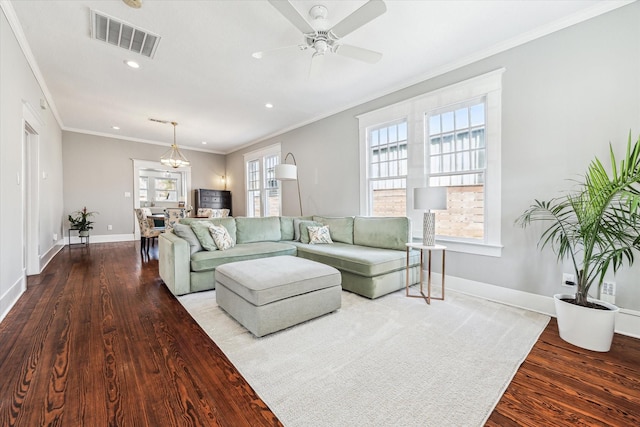 living room with wood finished floors, visible vents, baseboards, ceiling fan, and crown molding