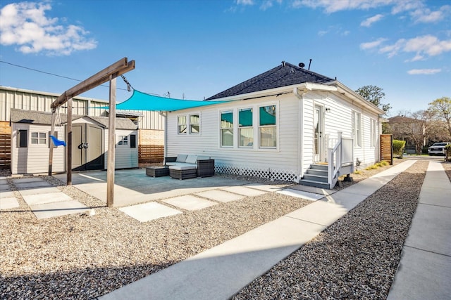 exterior space with a patio area, a shed, a shingled roof, and an outdoor structure