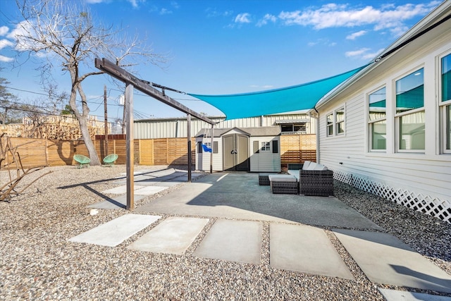 view of patio / terrace with an outbuilding, a fenced backyard, and a shed