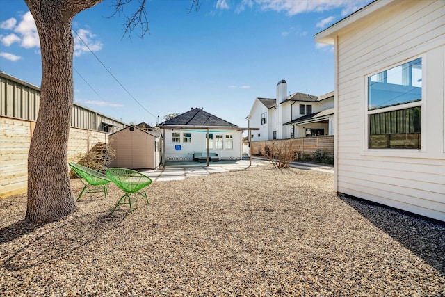 view of yard featuring a patio area, an outbuilding, and fence