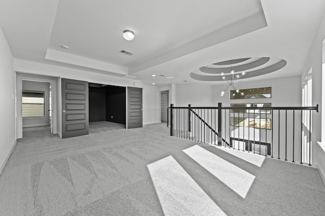 unfurnished room featuring a tray ceiling, baseboards, visible vents, and carpet floors