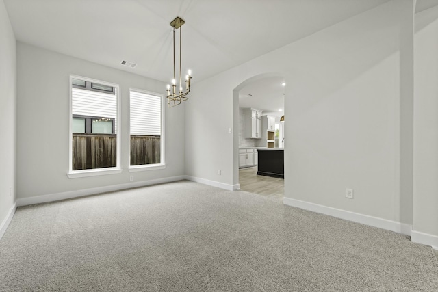 8407 Sheffields Leader, Fulshear, TX 77441 - empty room featuring light colored carpet, arched walkways, plenty of natural light, and a chandelier
