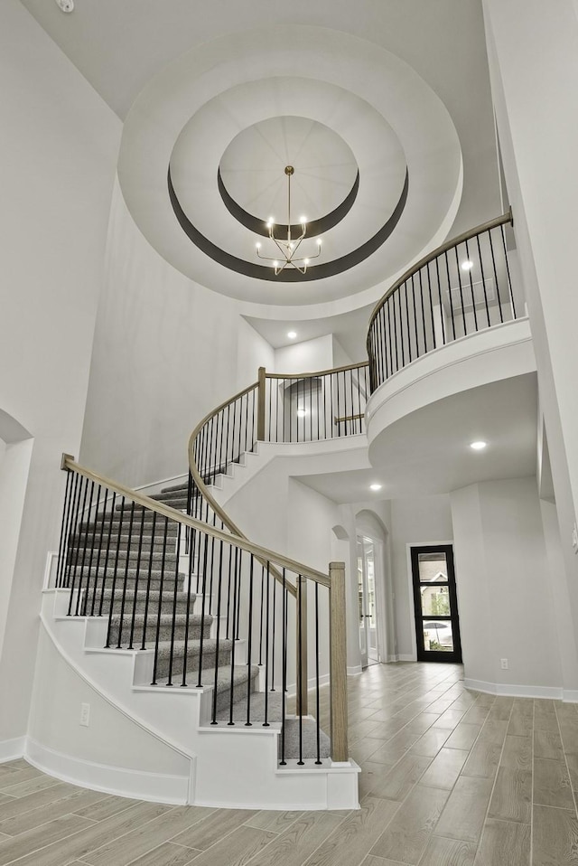 8407 Sheffields Leader, Fulshear, TX 77441 - stairway featuring a towering ceiling, wood finished floors, a chandelier, and recessed lighting