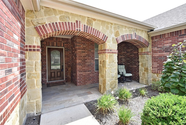 entrance to property featuring brick siding and stone siding