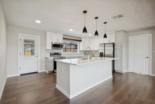 kitchen with visible vents, stainless steel appliances, dark wood-type flooring, and a sink