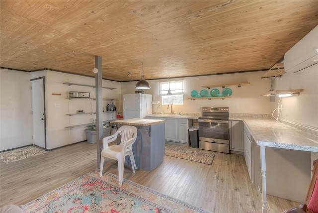 kitchen featuring light countertops, wooden ceiling, stainless steel range with electric stovetop, freestanding refrigerator, and light wood-style floors