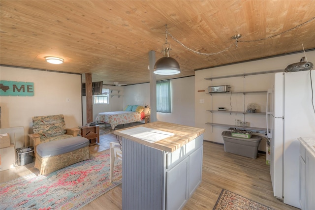 bedroom featuring wood ceiling, freestanding refrigerator, and light wood-style floors