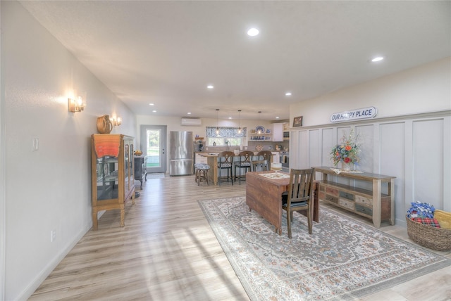 living room featuring recessed lighting, light wood-style floors, and a wall mounted AC