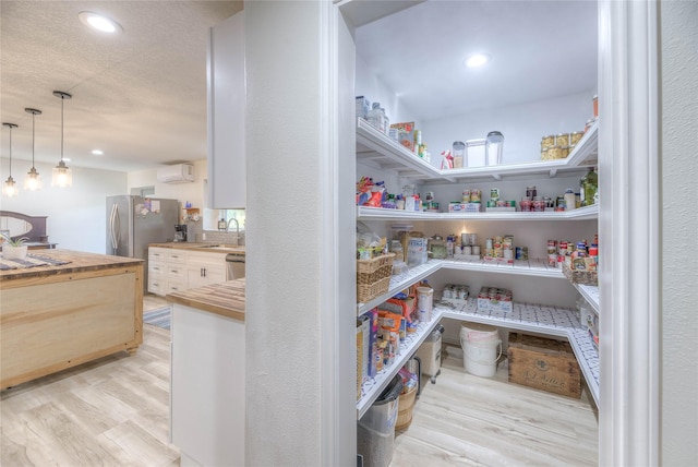 storage area featuring a sink and a wall mounted AC