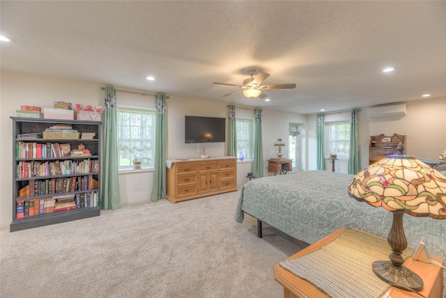 carpeted bedroom featuring multiple windows, recessed lighting, and a wall mounted AC