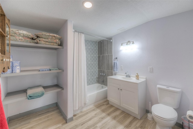 full bathroom with shower / bath combo with shower curtain, toilet, a textured ceiling, wood finished floors, and vanity