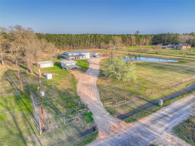 bird's eye view featuring a wooded view and a water view