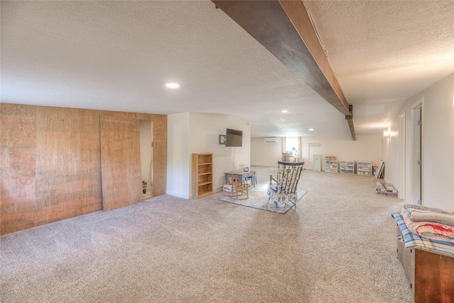 finished below grade area with recessed lighting, wood walls, carpet floors, and a textured ceiling