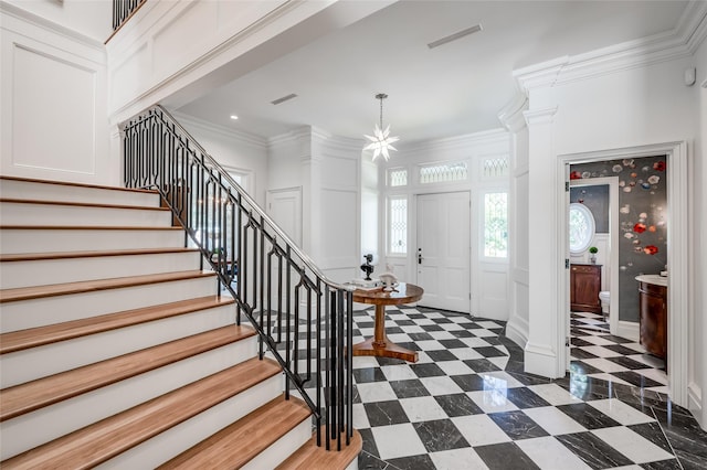 2131 Brentwood Dr, Houston, TX 77019 - foyer entrance featuring a decorative wall, stairway, ornamental molding, ornate columns, and dark flooring