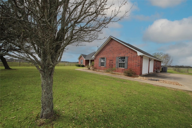 exterior space with fence, an attached garage, driveway, a front yard, and brick siding
