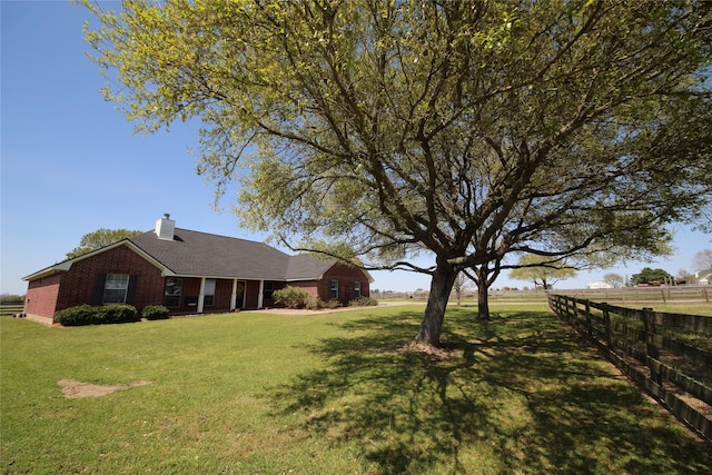 ranch-style house with brick siding, fence, a front lawn, and a chimney