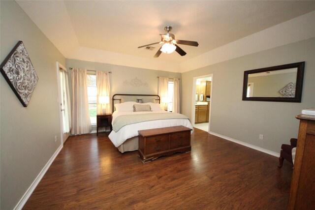 bedroom with a tray ceiling, baseboards, wood finished floors, and a ceiling fan