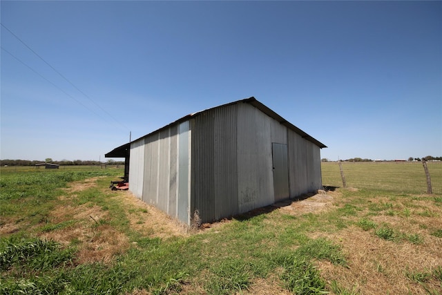 view of pole building with a rural view and a yard